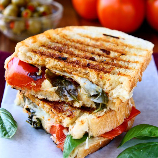 Caprese panini sandwich on parchment paper.