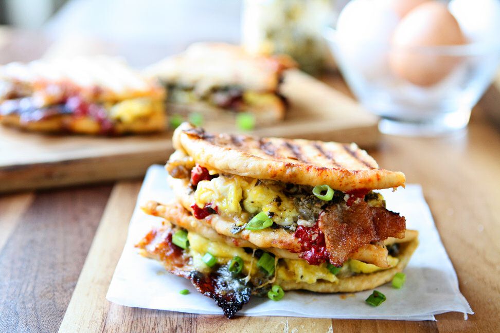 Breakfast Panini | Take your breakfast to the next level! Sun-Dried tomato pita bread, pesto, three kinds of cheese, scrambled eggs, bacon, sausage, roasted red peppers and scallions. A delicious and hearty breakfast sandwich that will keep you going all morning. Ready in less than 30 minutes!| heavenlyhomecooking.com