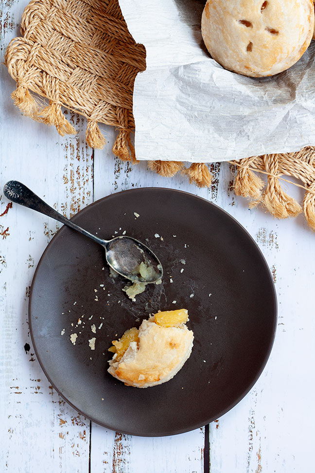 Overhead photo of a half-eaten pie sitting on a plate with spoon.