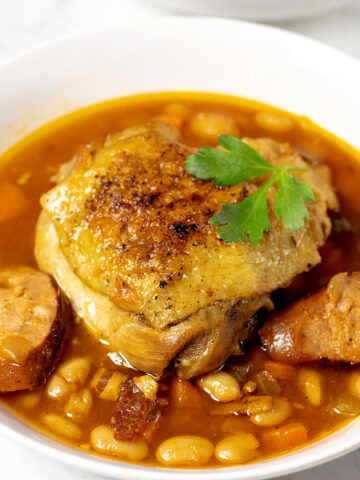 Close up of chicken and sausage stew in a white bowl
