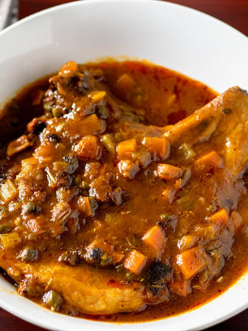 Smothered pork chops in a white bowl.