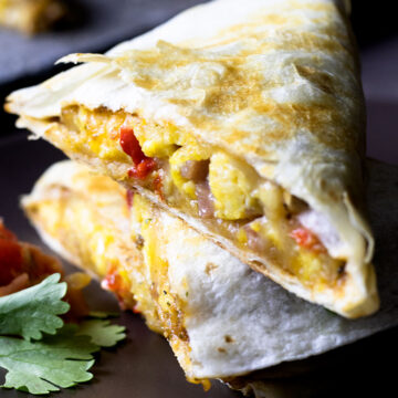 Close up of stacked breakfast quesadilla on a brown plate