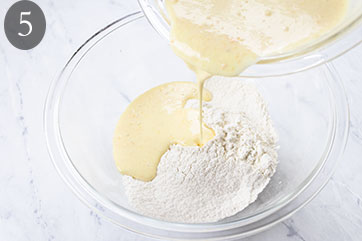 Wet ingredients being poured into dry ingredients.