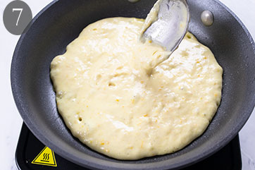 Batter being spooned into a skillet.