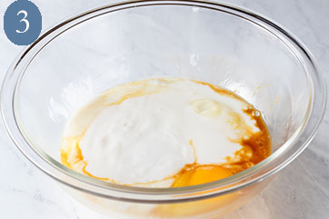 Glass bowl containing wet ingredients to make buttermilk waffles