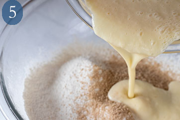 Wet ingredients being poured into dry ingredients to make buttermilk waffles