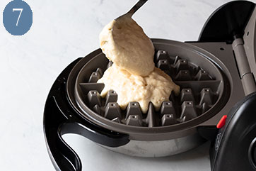 Pouring waffle batter into a waffle iron