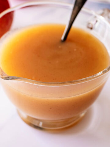 Apple syrup in a glass pitcher with spoon