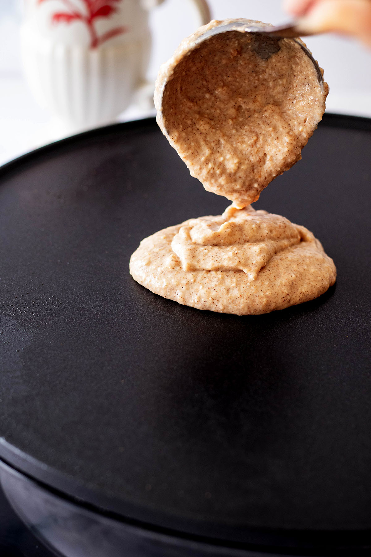 Pancake batter being ladled onto a griddle
