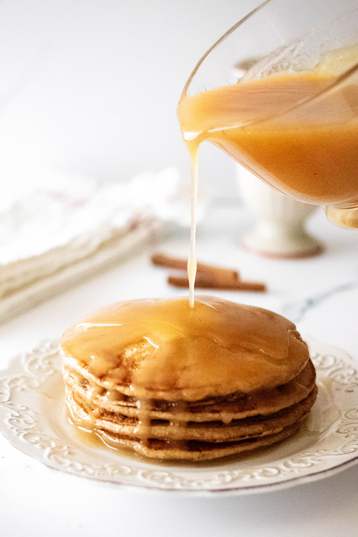 Syrup being poured on cinnamon oatmeal pancakes