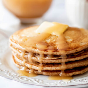Stack of cinnamon oatmeal pancakes on a white plate