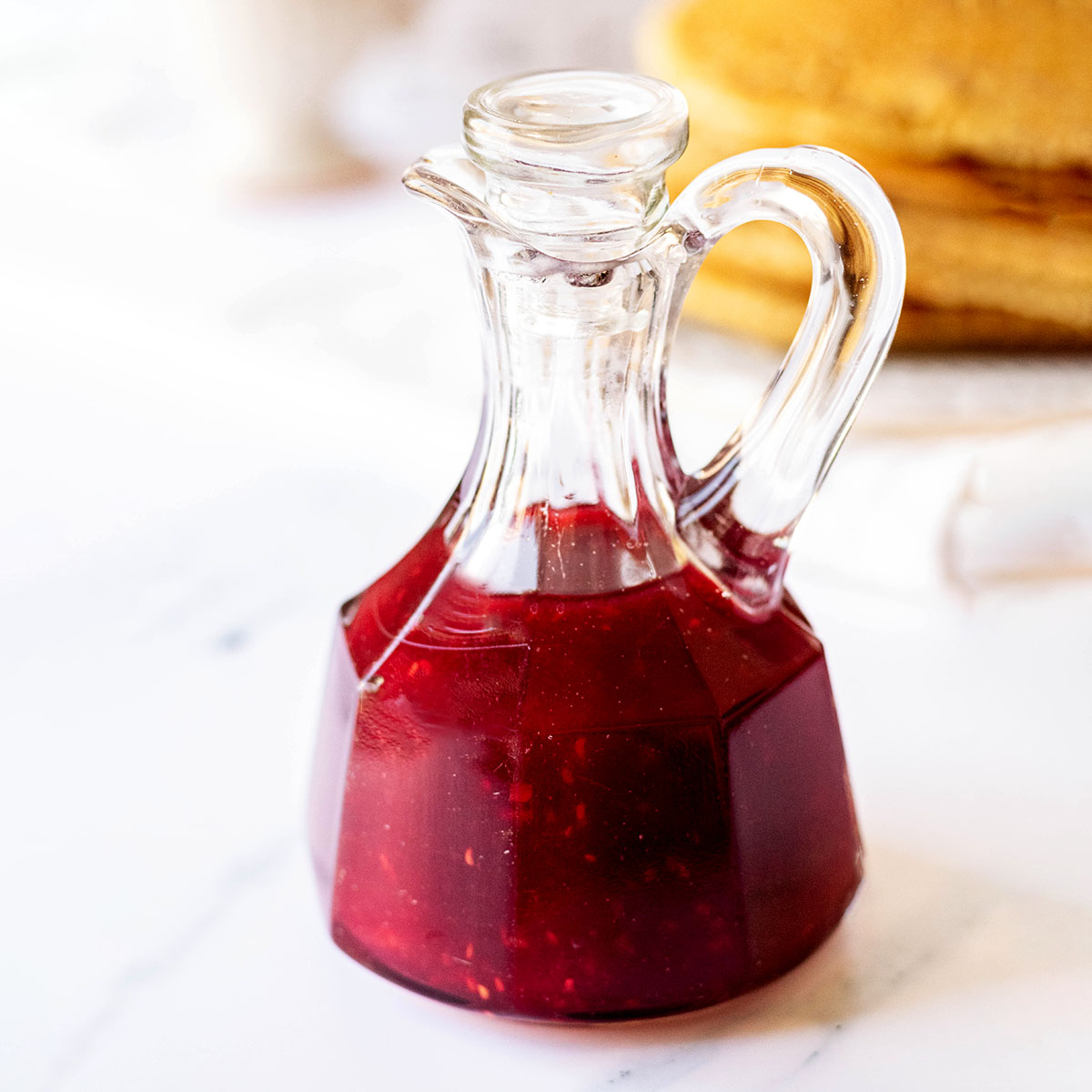 Raspberry syrup in a glass cruet