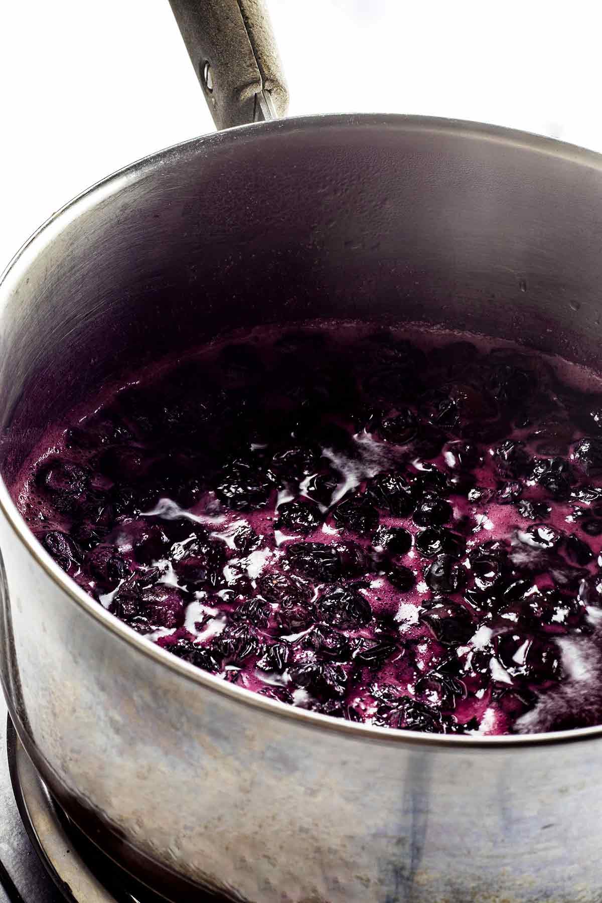 Blueberry syrup cooking in a saucepan