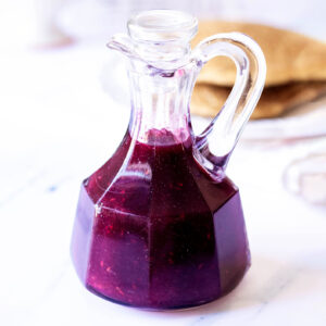 Mixed berry syrup in a glass carafe