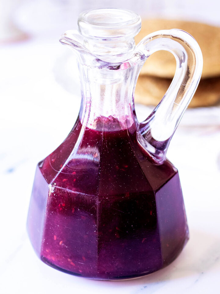 Mixed berry syrup in a glass carafe