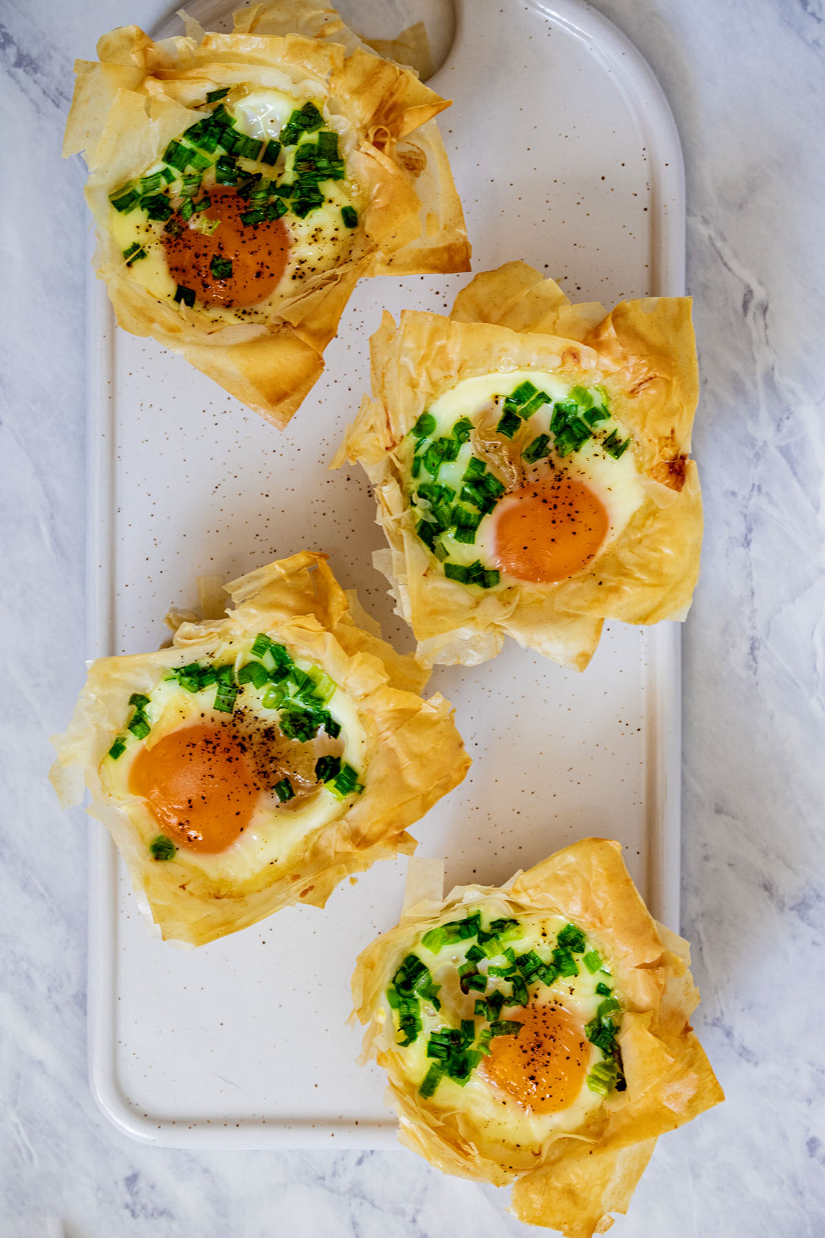 Overhead view of phyllo breakfast cups on a white tray