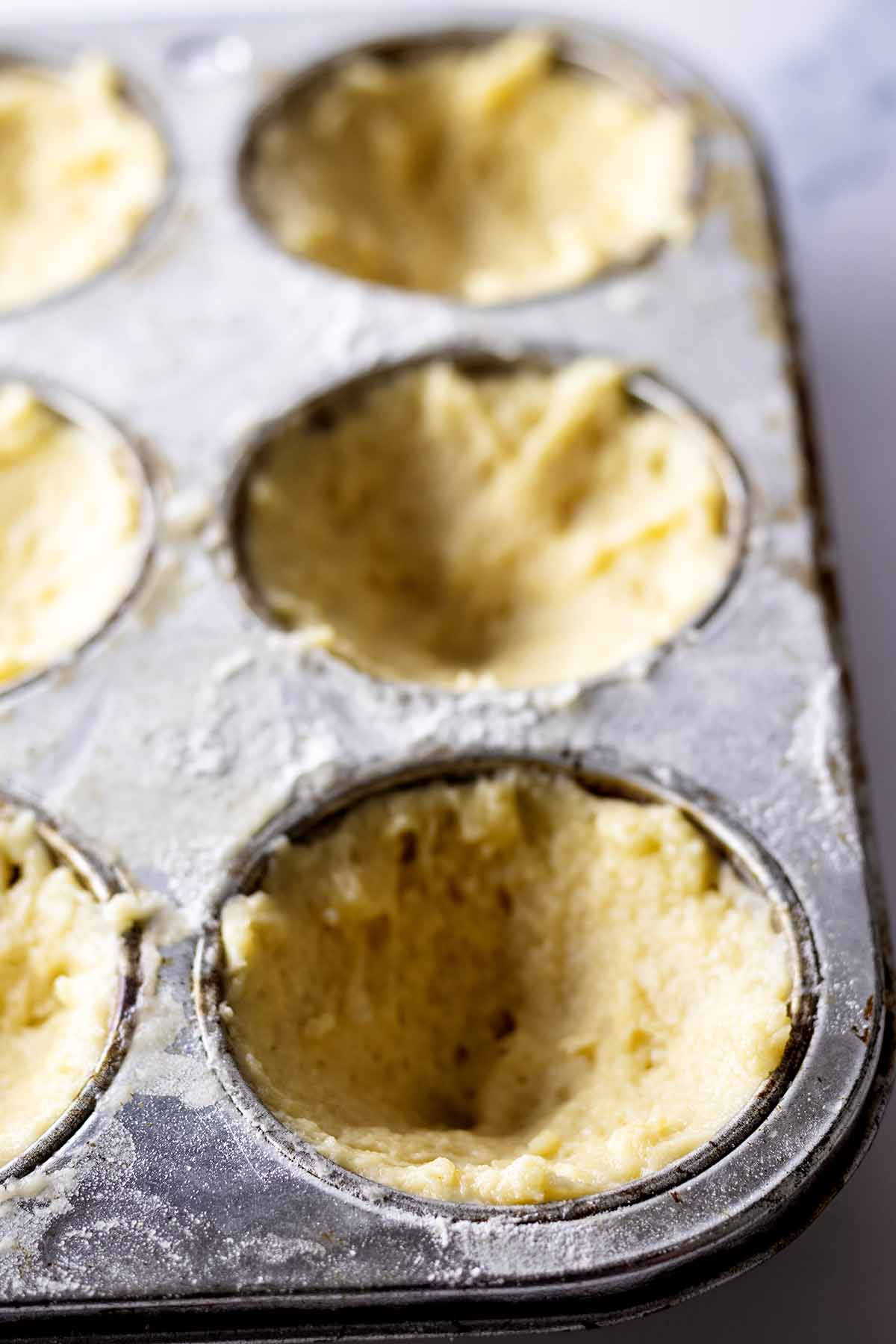 Biscuit muffin batter in a muffin tin