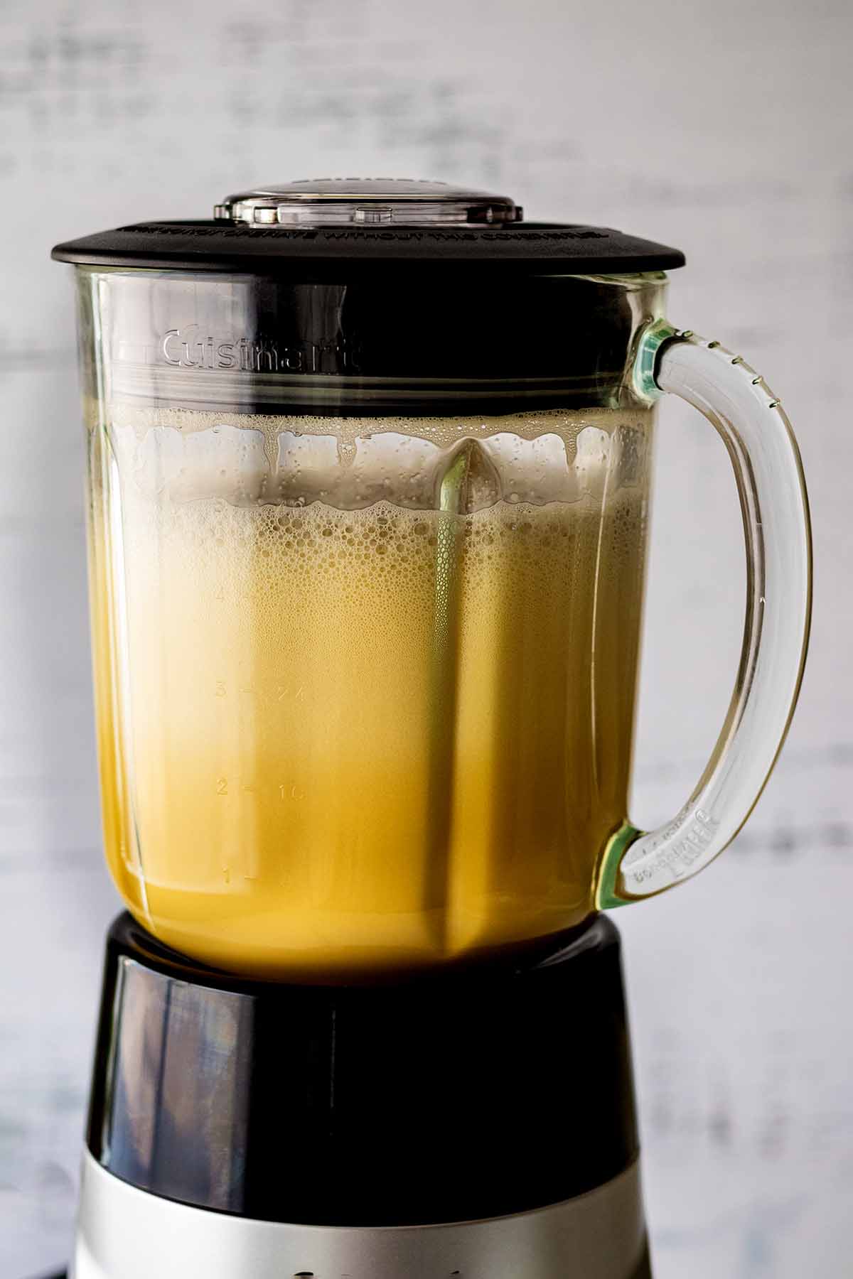 Frothy egg and green chile liquid in a blender.