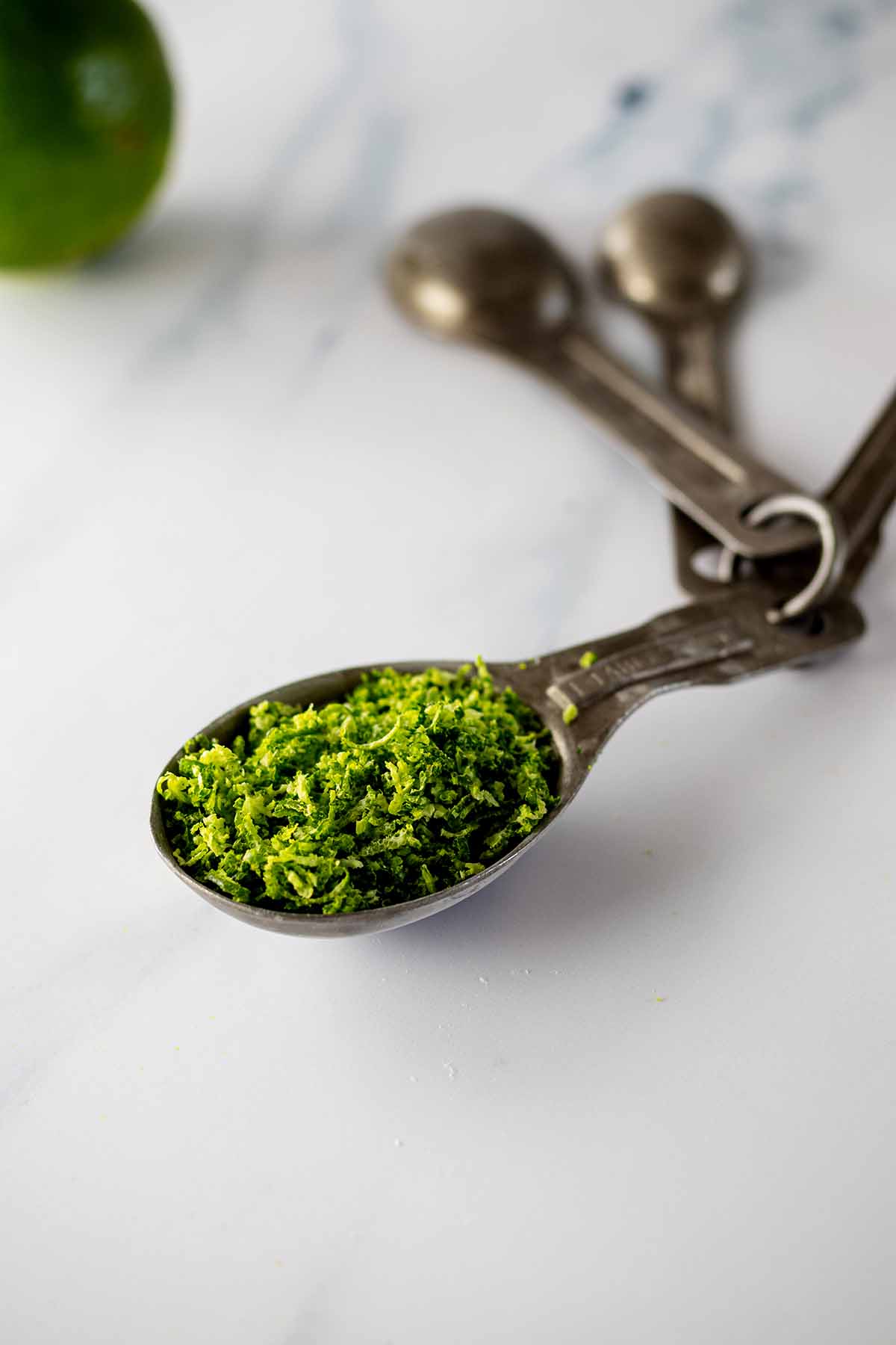 Lime zest in a measuring spoon