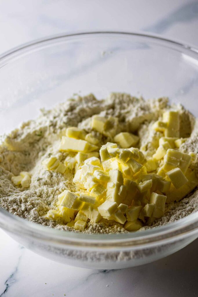 Chopped butter in a bowl with dry ingredients