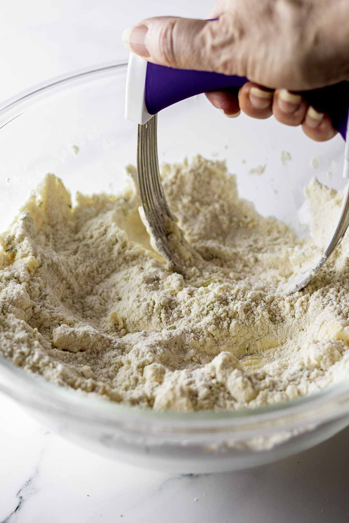 Mixing butter into dry ingredients with a pastry cutter