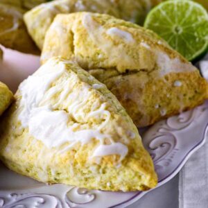 Lime scones on a white plate with limes