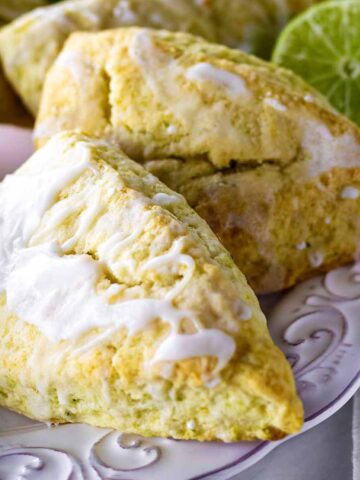 Lime scones on a white plate with limes