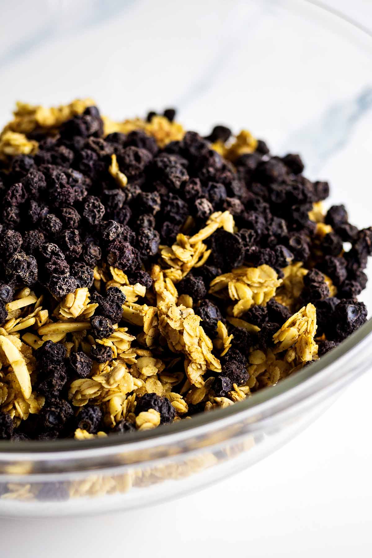 Dried blueberries in a glass bowl with granola clusters