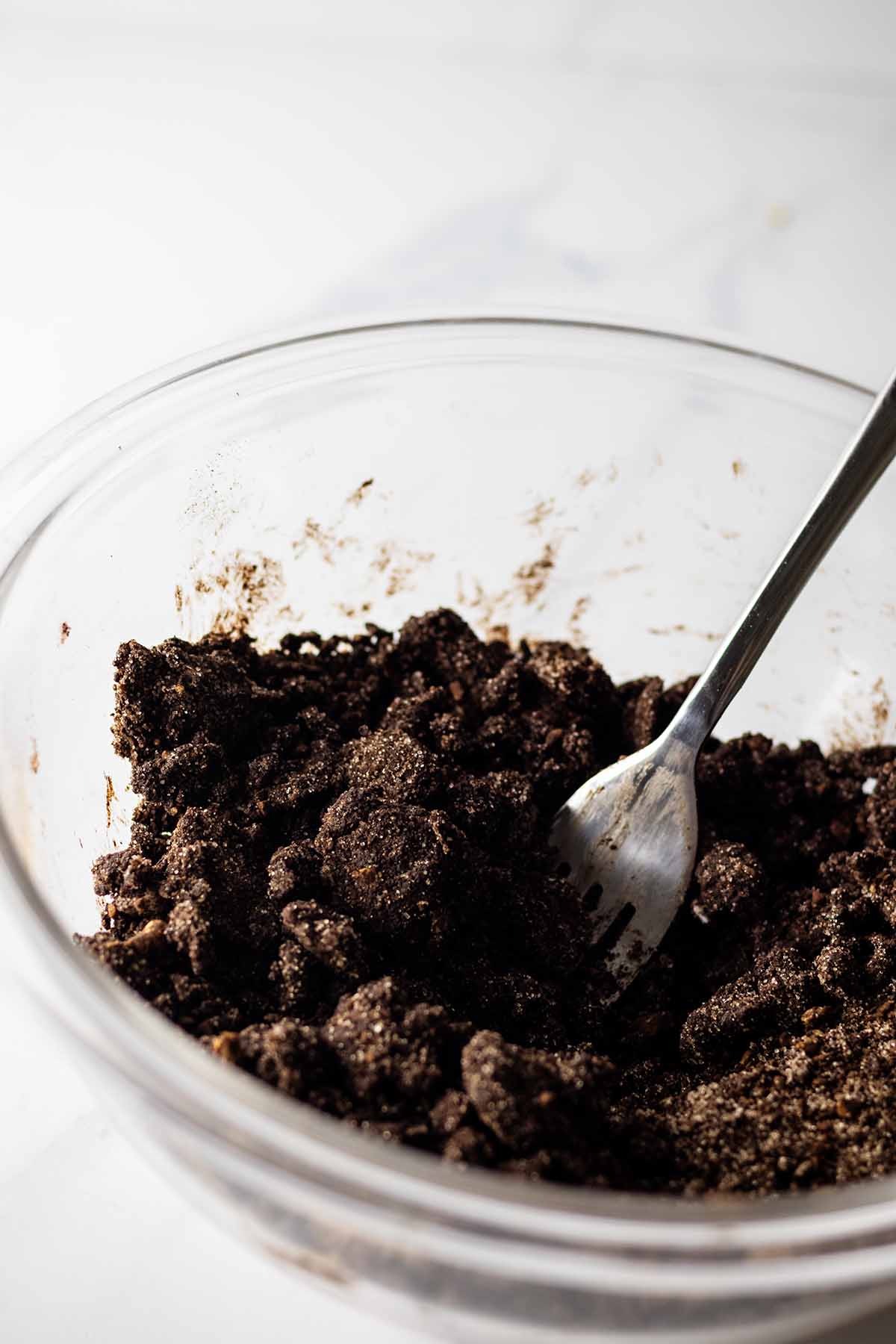 Chocolate crumb topping in a glass bowl with a fork