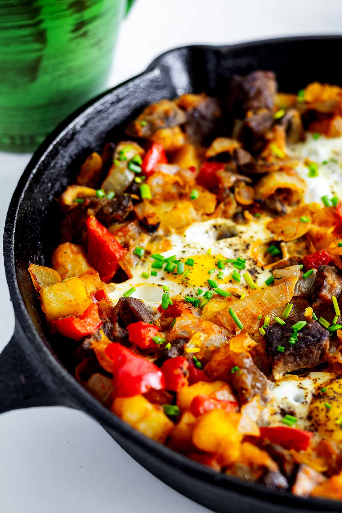 Close up of steak and eggs hash in a cast iron skillet