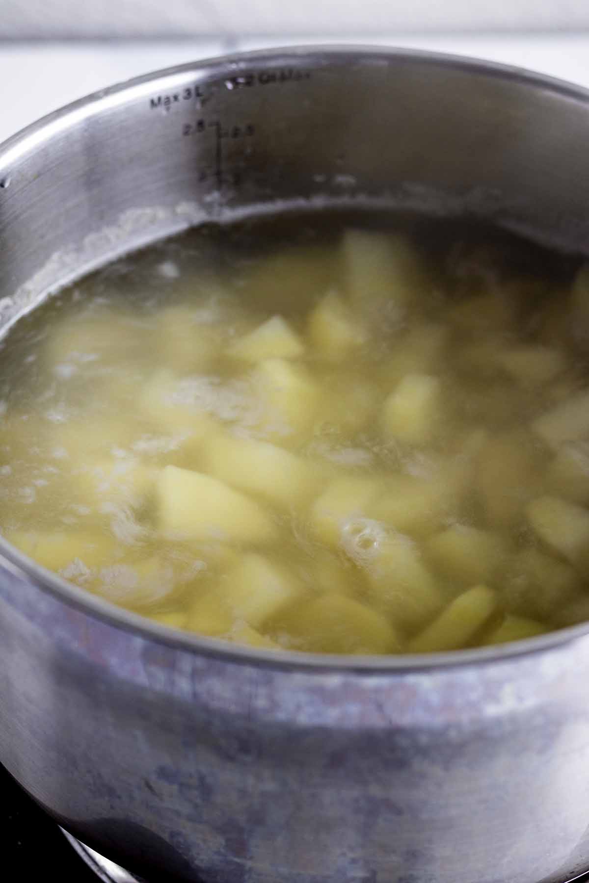Peeled and chopped potatoes cooking in a saucepan