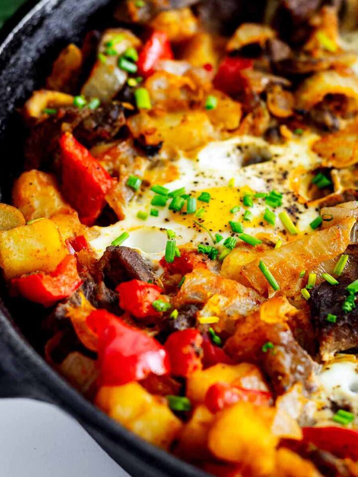 Close up of steak and eggs hash in a cast iron skillet