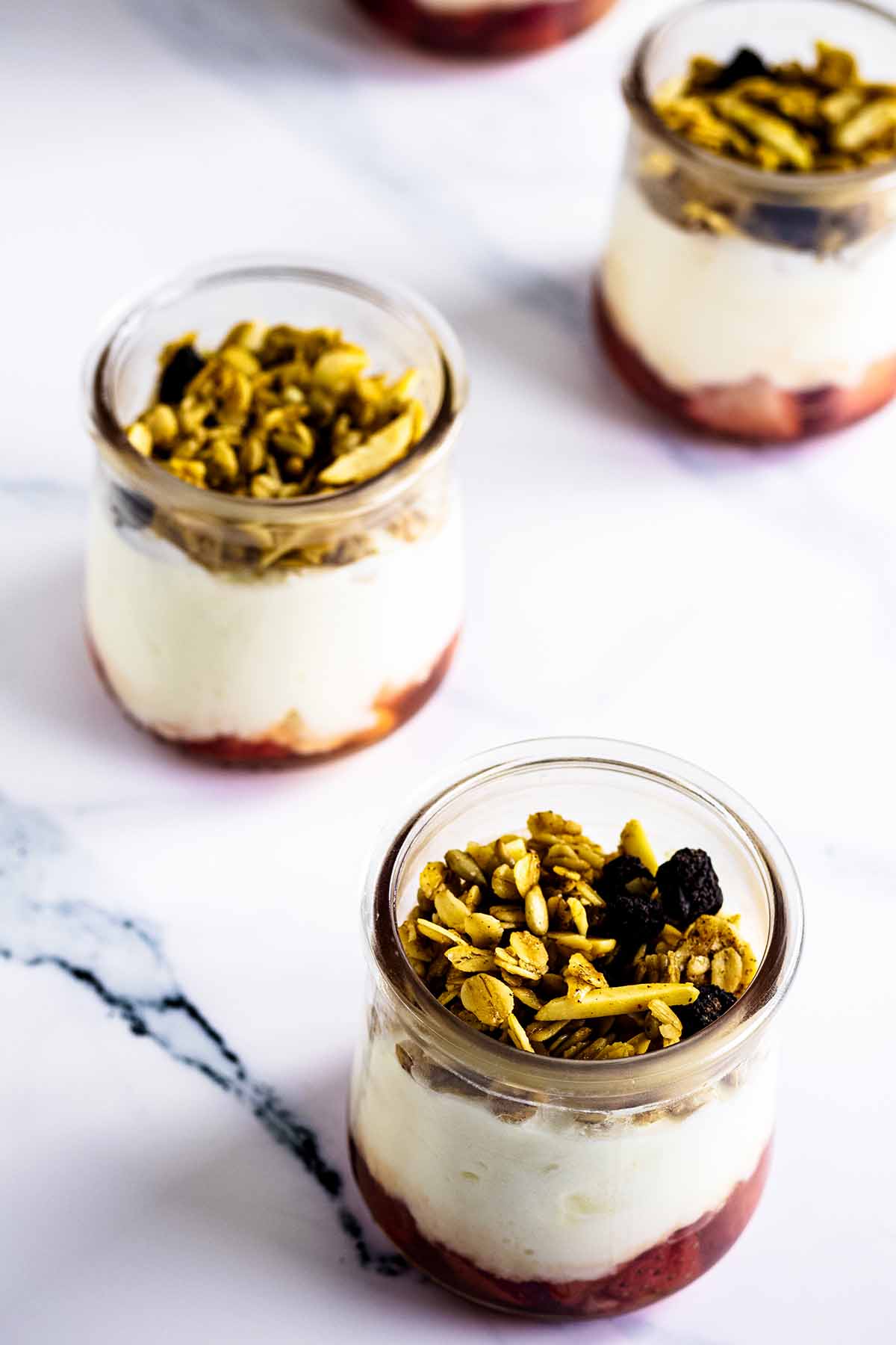 Granola on top of parfaits in glass jars