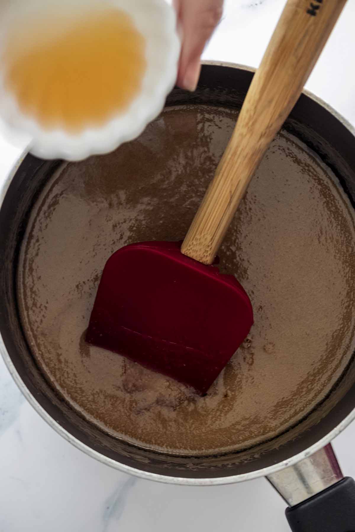 Vanilla extract being added to a saucepan