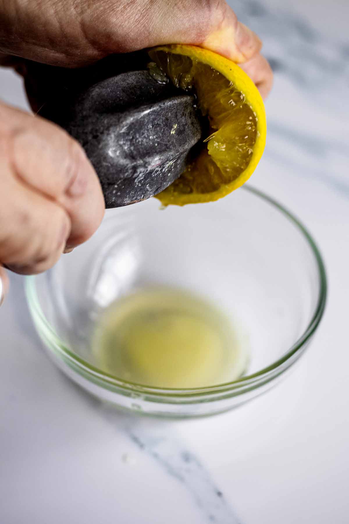 Squeezing lemon juice into a small glass bowl