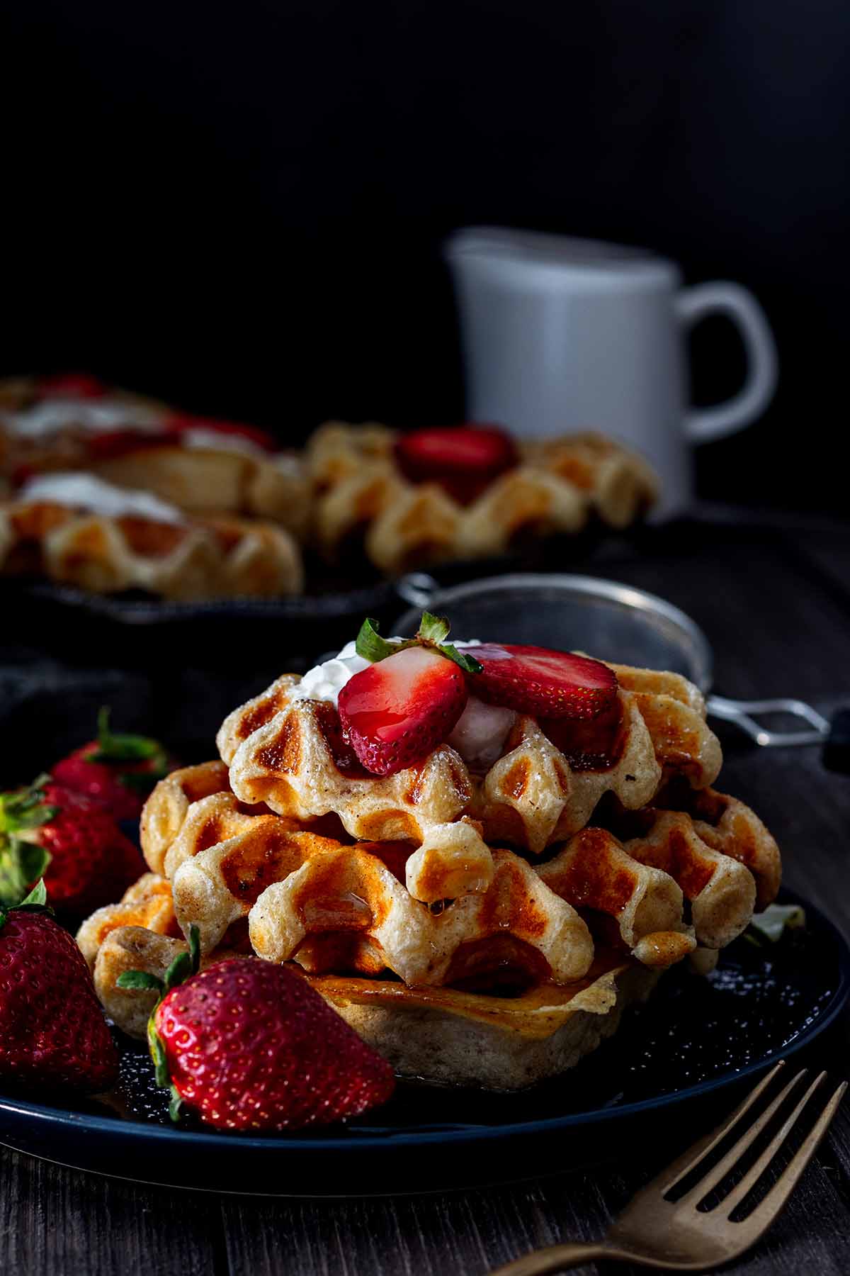 Stack of waffles on a blue plate with strawberries