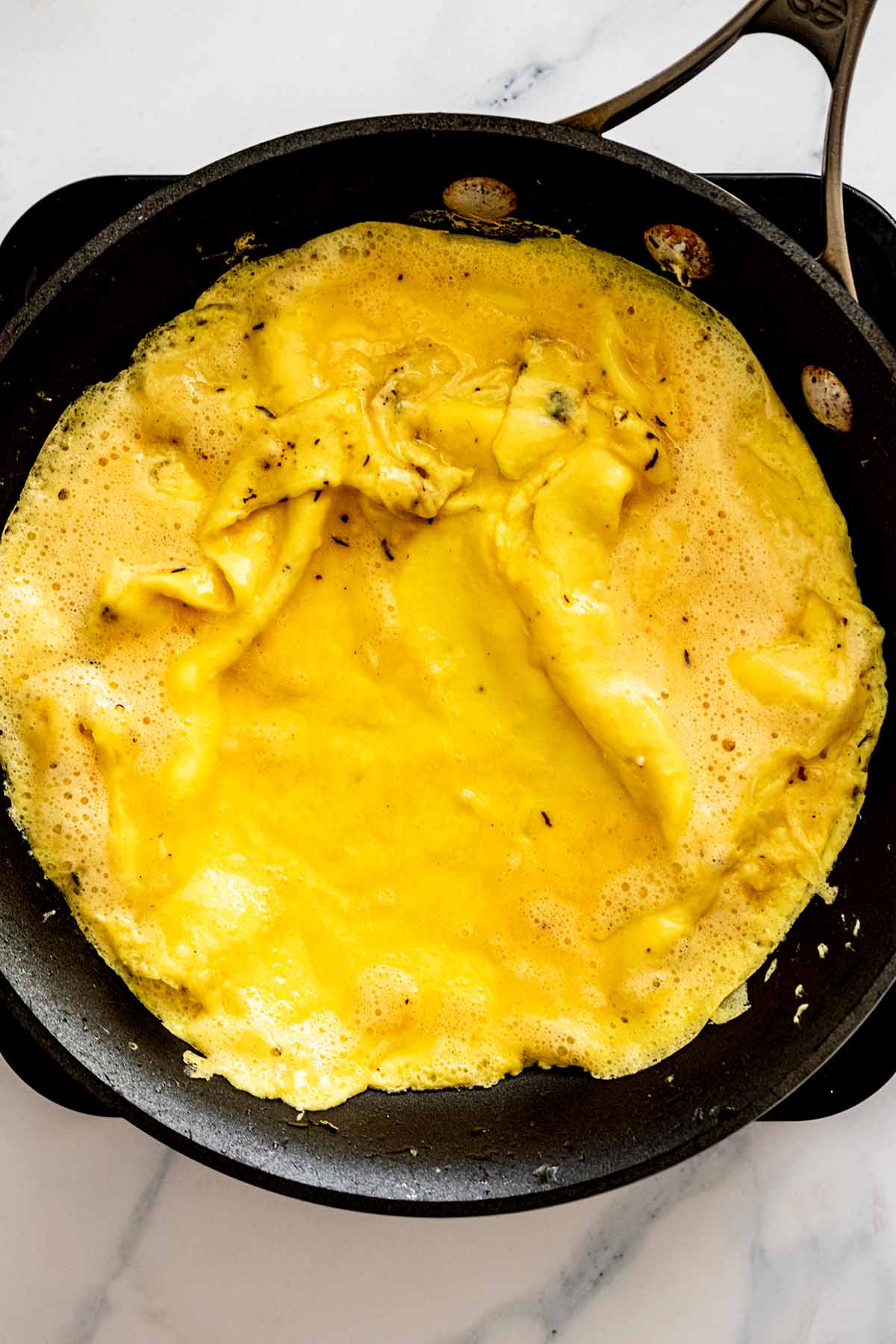 Semi-cooked omelette in a skillet