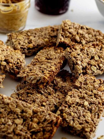Pile of peanut butter & jelly breakfast bars on a marble countertop.