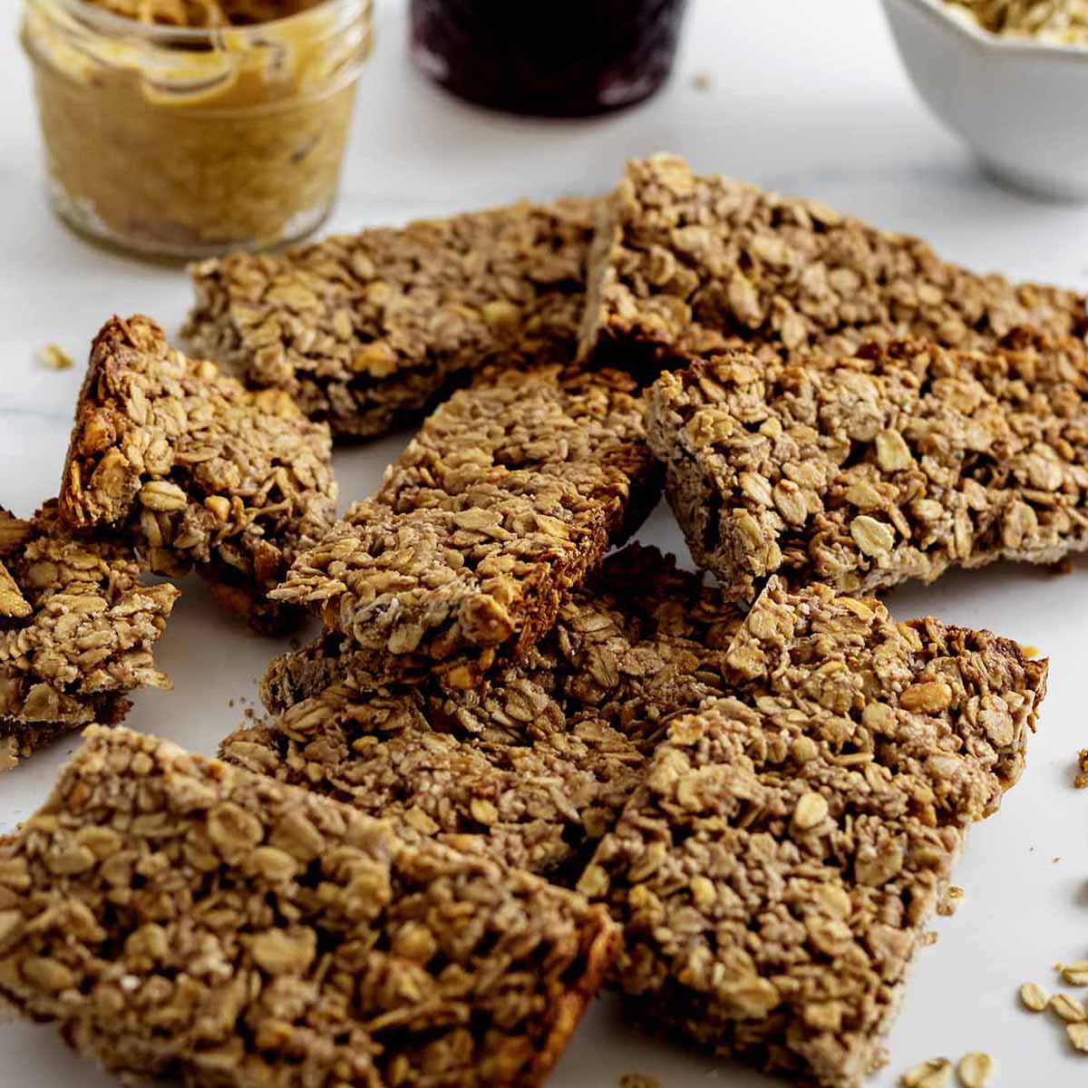 Pile of peanut butter & jelly breakfast bars on a marble countertop.