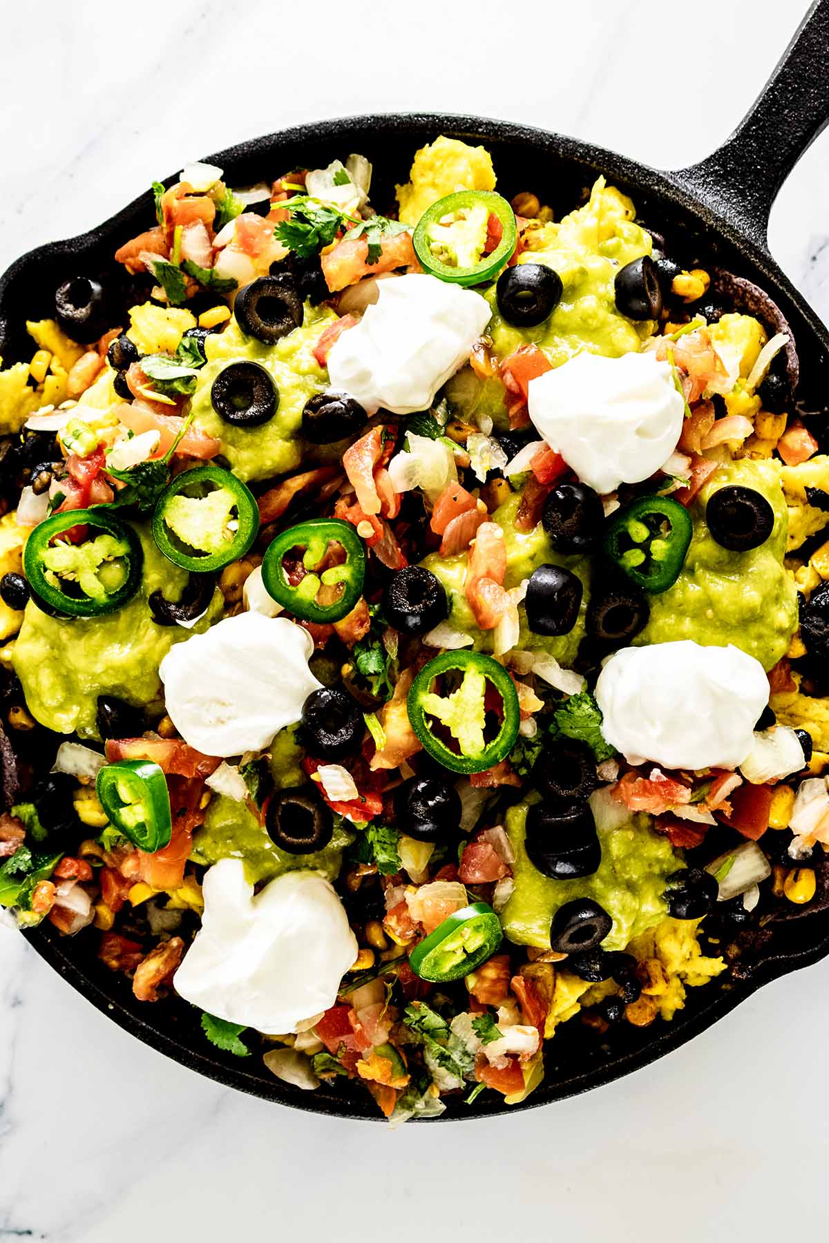 Overhead view of breakfast nachos in a cast iron skillet