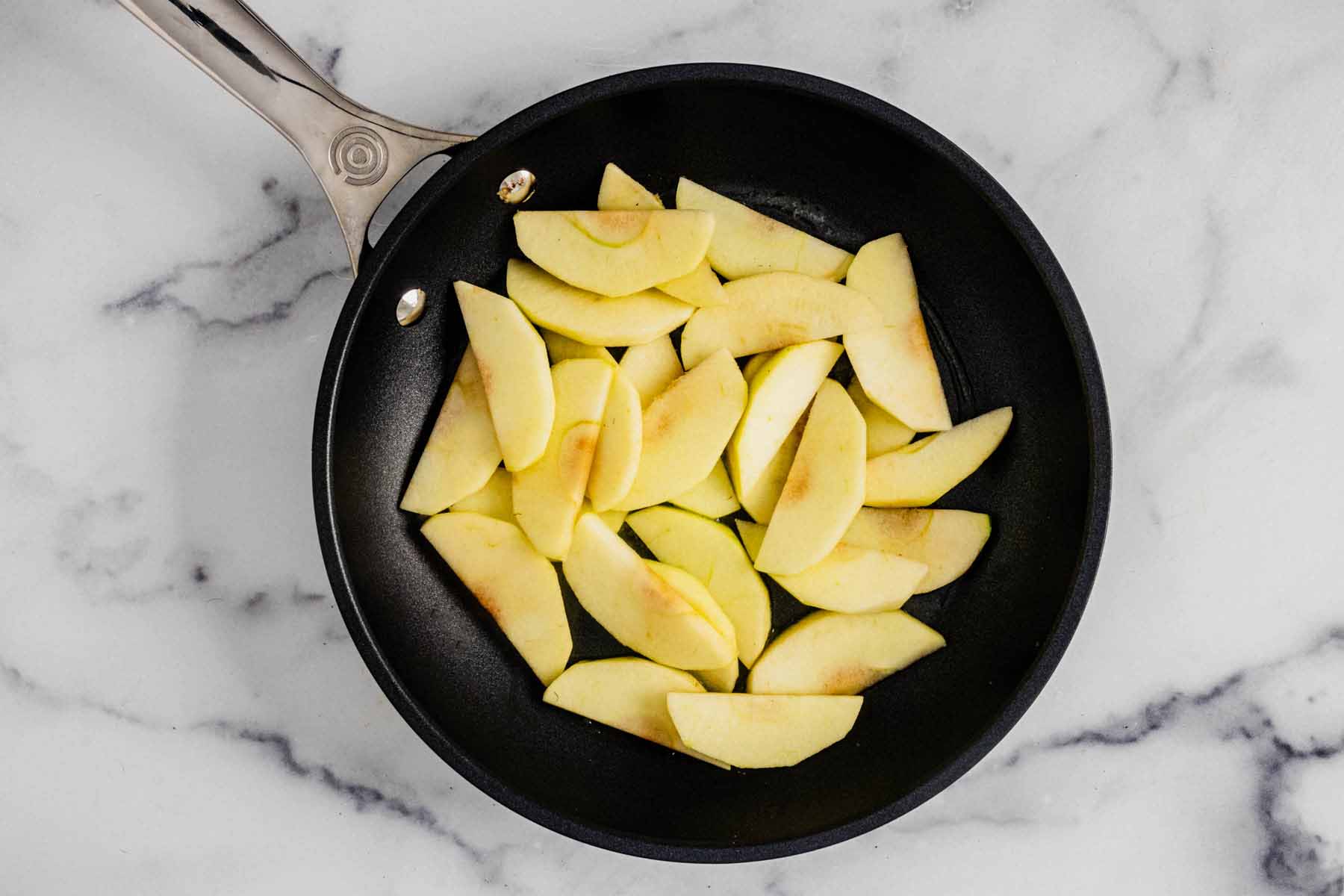 Apple slices in a small skillet.