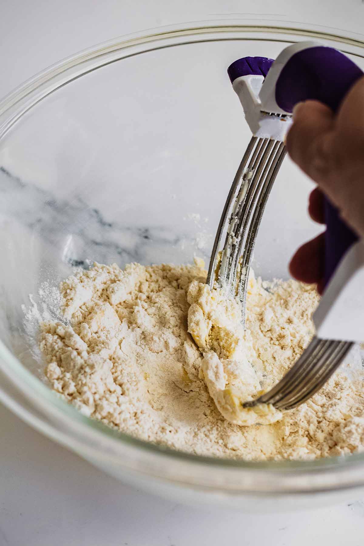 Flour and butter in a glass bowl with a pastry cutter