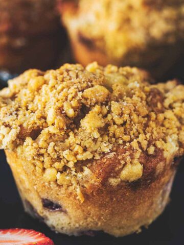 Strawberry muffins on a blue plate with sliced strawberries