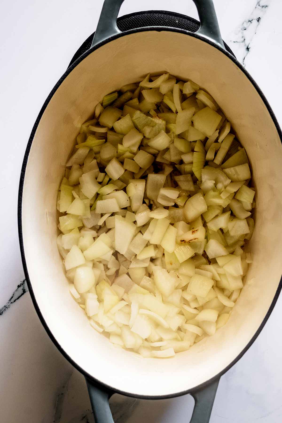 Overhead view of onions cooking in soup pot