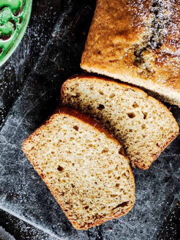 Overhead view of cardamom quick bread on a dark grey trivet