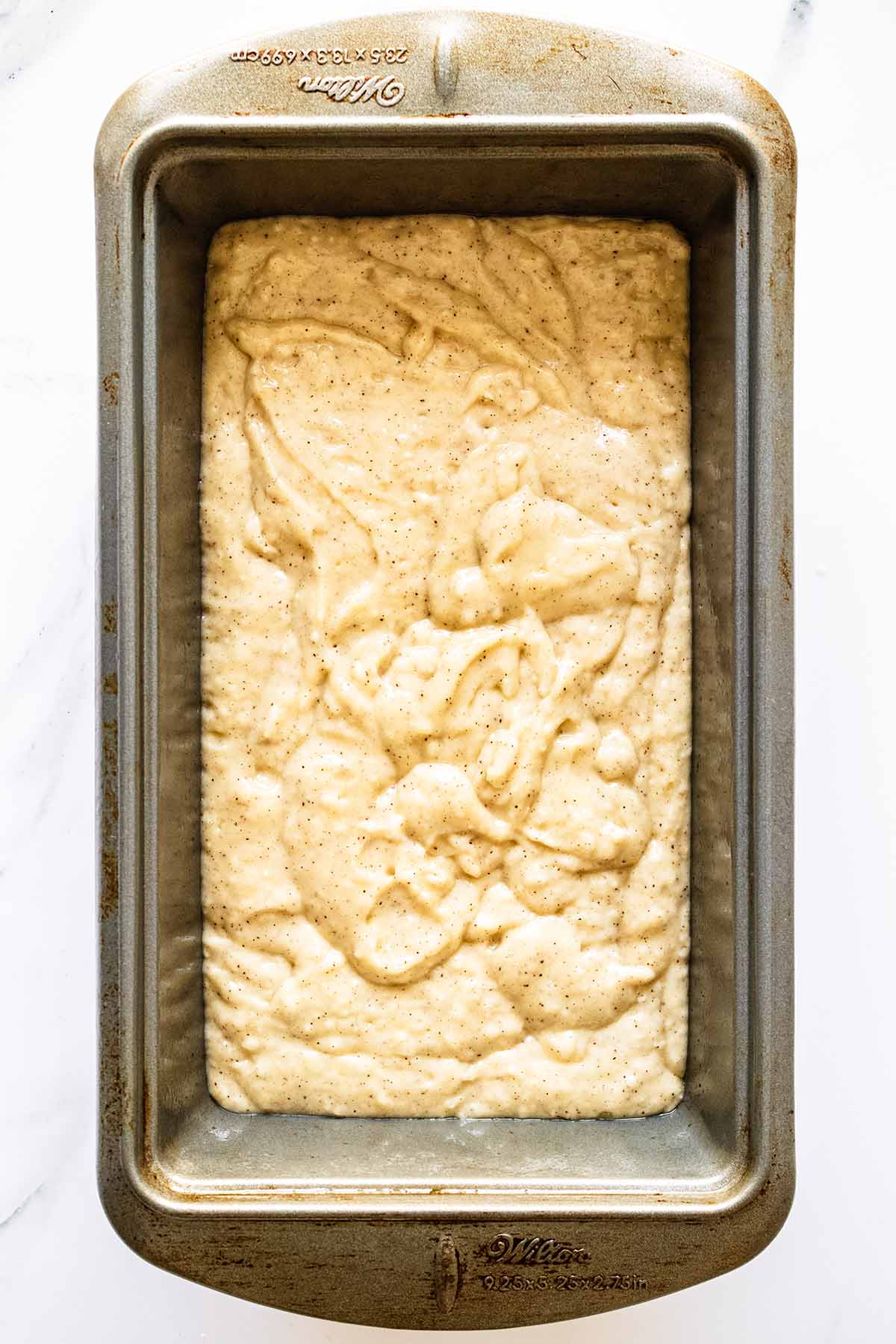 Overhead view of bread batter in a loaf pan