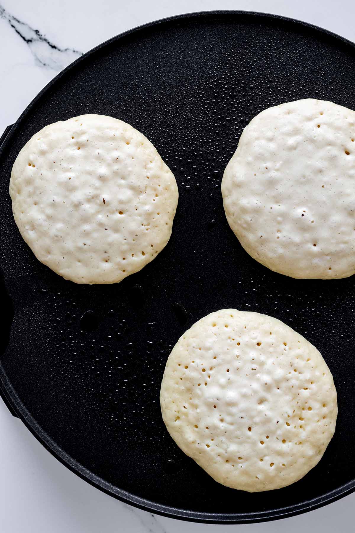 Overhead view of pancakes with popped air bubbles