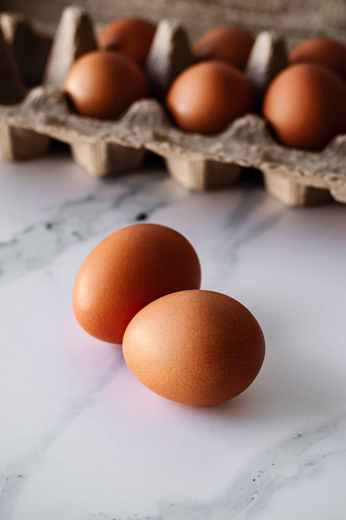 Two eggs on a marble countertop.