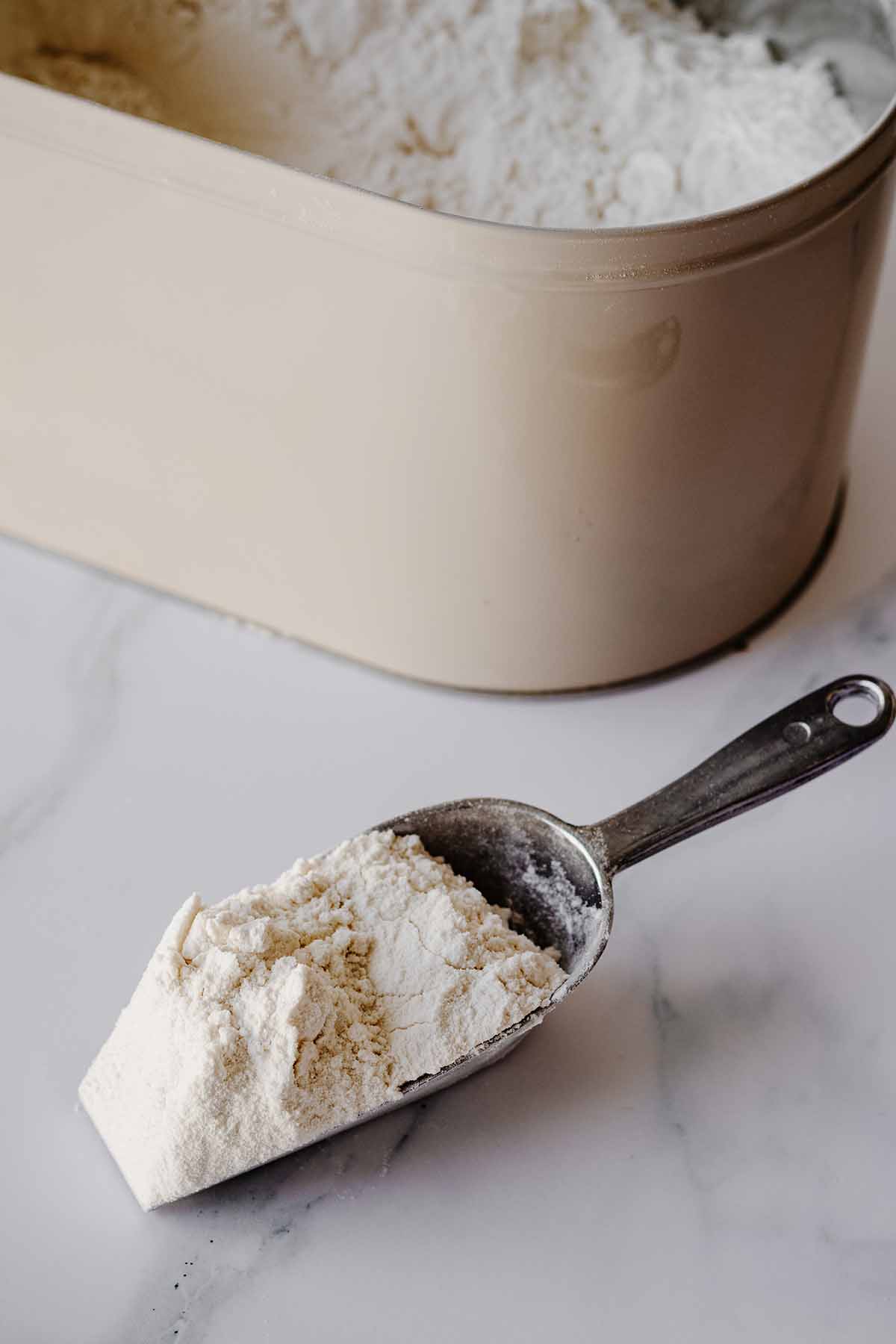 Scoop of white all purpose flour on a marble background