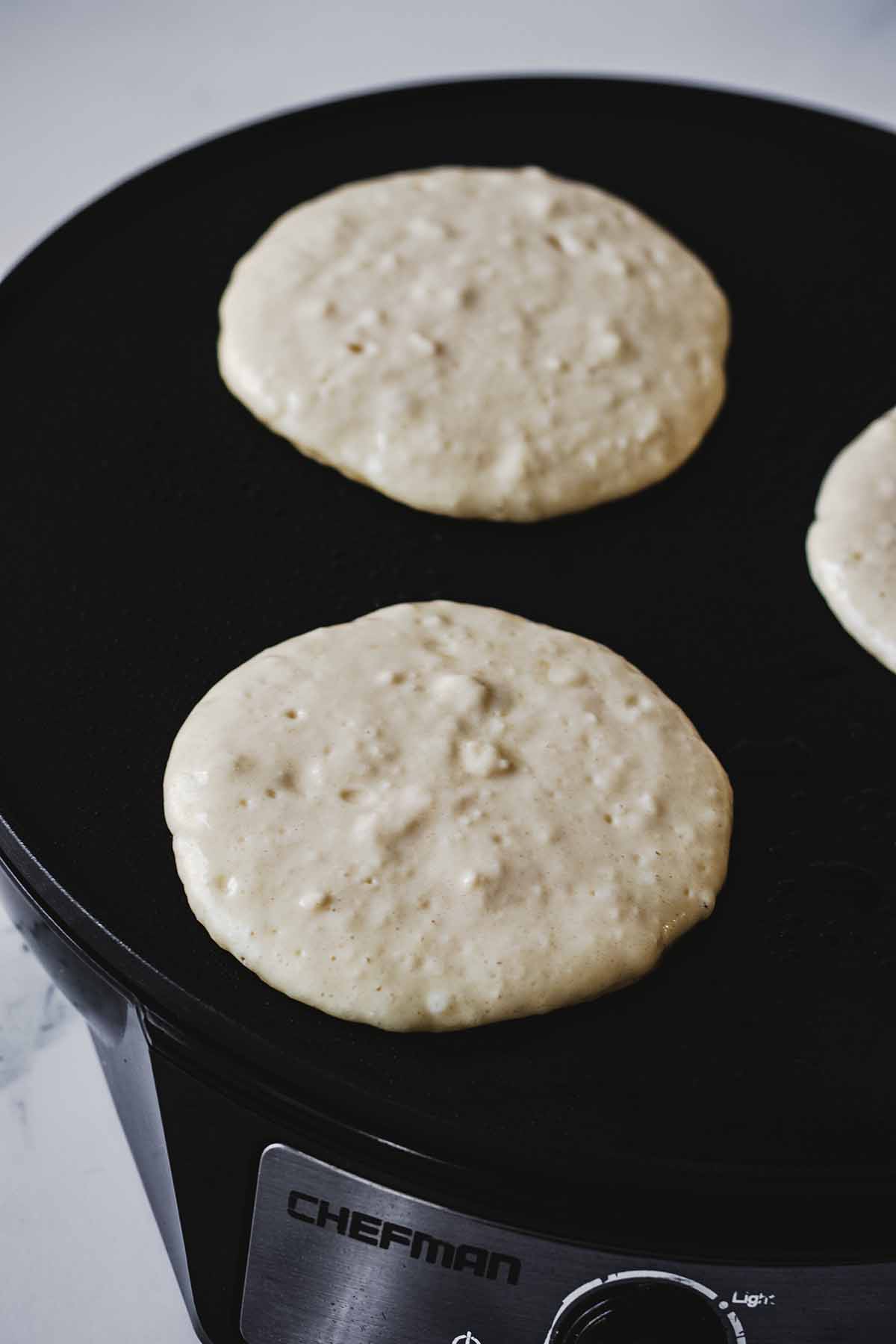 Pancakes cooking on an electric griddle